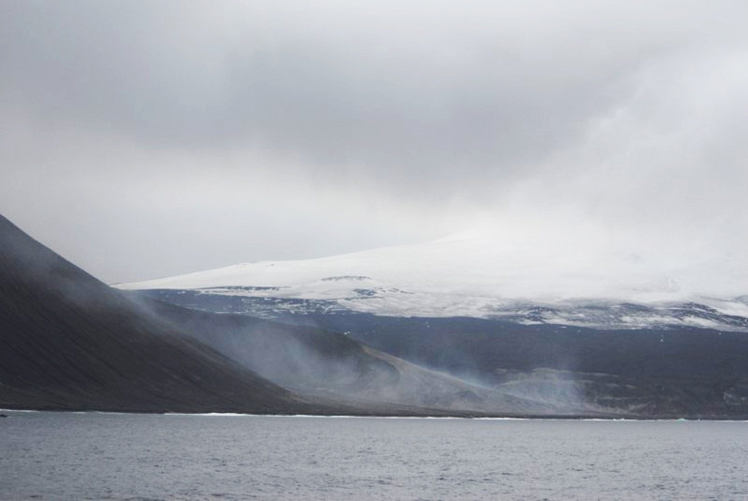 Vulkanische Insel der Südlichen Sandwichinseln, teils in Wolken, mit Gletscher am Hang
