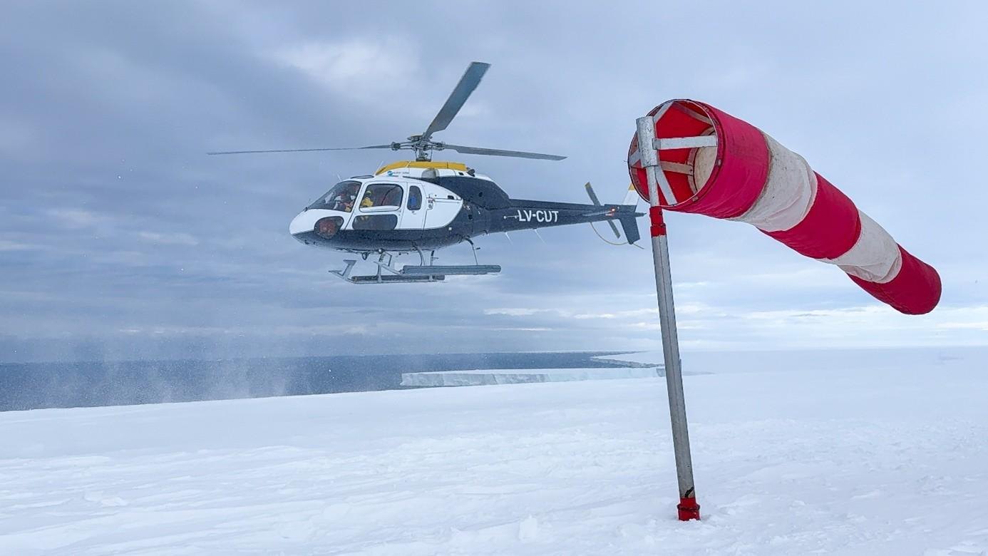 Hubschrauber im Anflug neben dem Windsack der MS Ortelius in der Antarktis