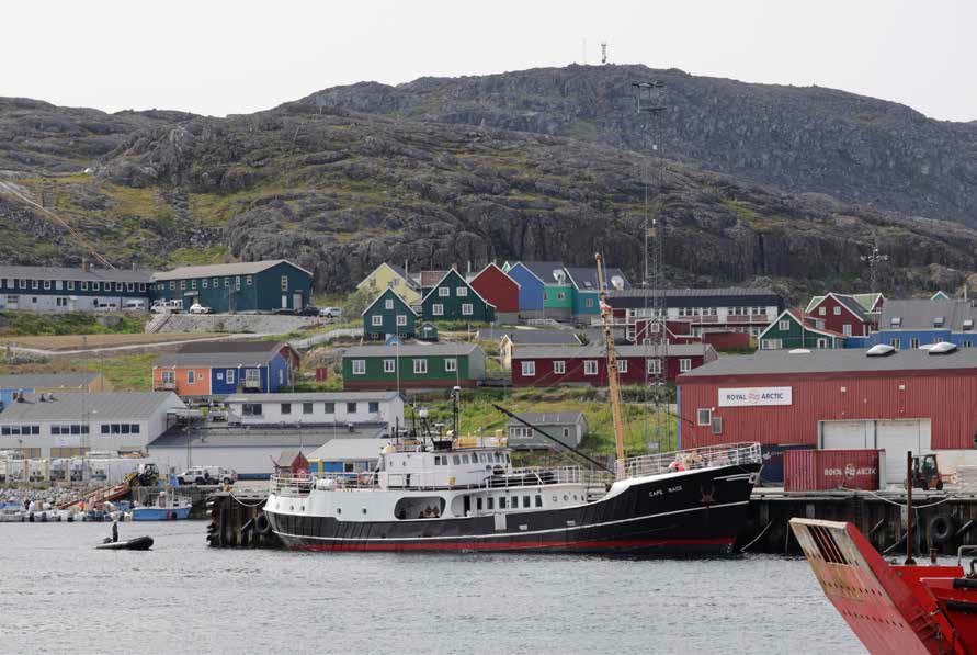 Der Hafen von Qaqortoq mit bunten Häusern am Hang und der Cape Race am Kai