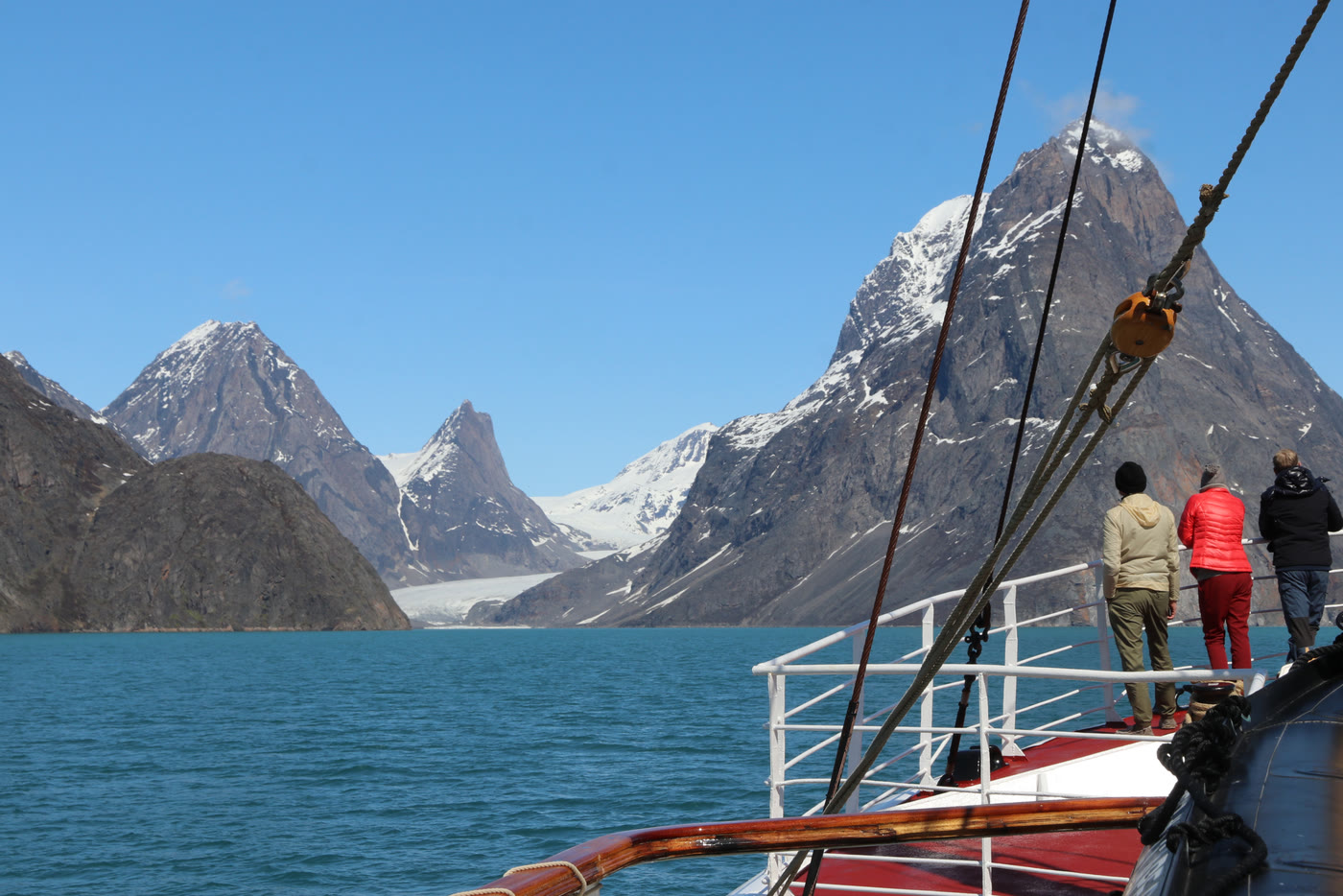 Verschneiter Berg mit Gletscher über dem Wasser des Evighedsfjords
