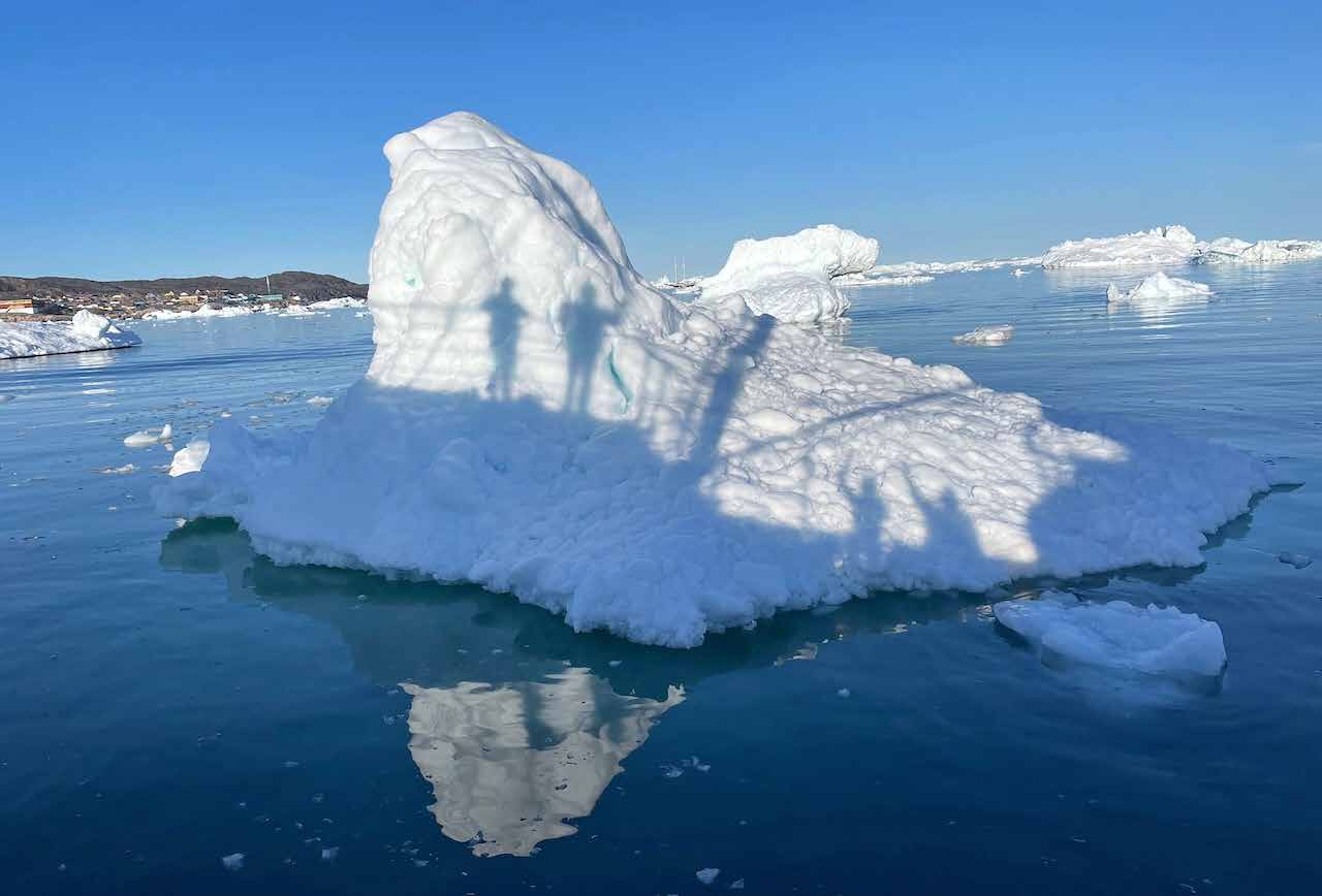 Großer Eisberg vor der Küste bei Ilulissat, im Hintergrund die Stadt