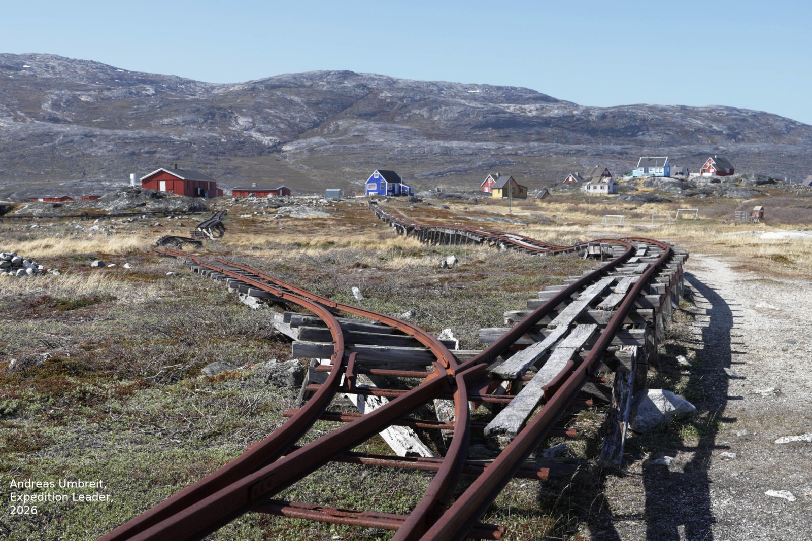 Verrostete Schienen führen zu einer aufgegebenen Fischfabrik in einer verlassenen Siedlung in Westgrönland