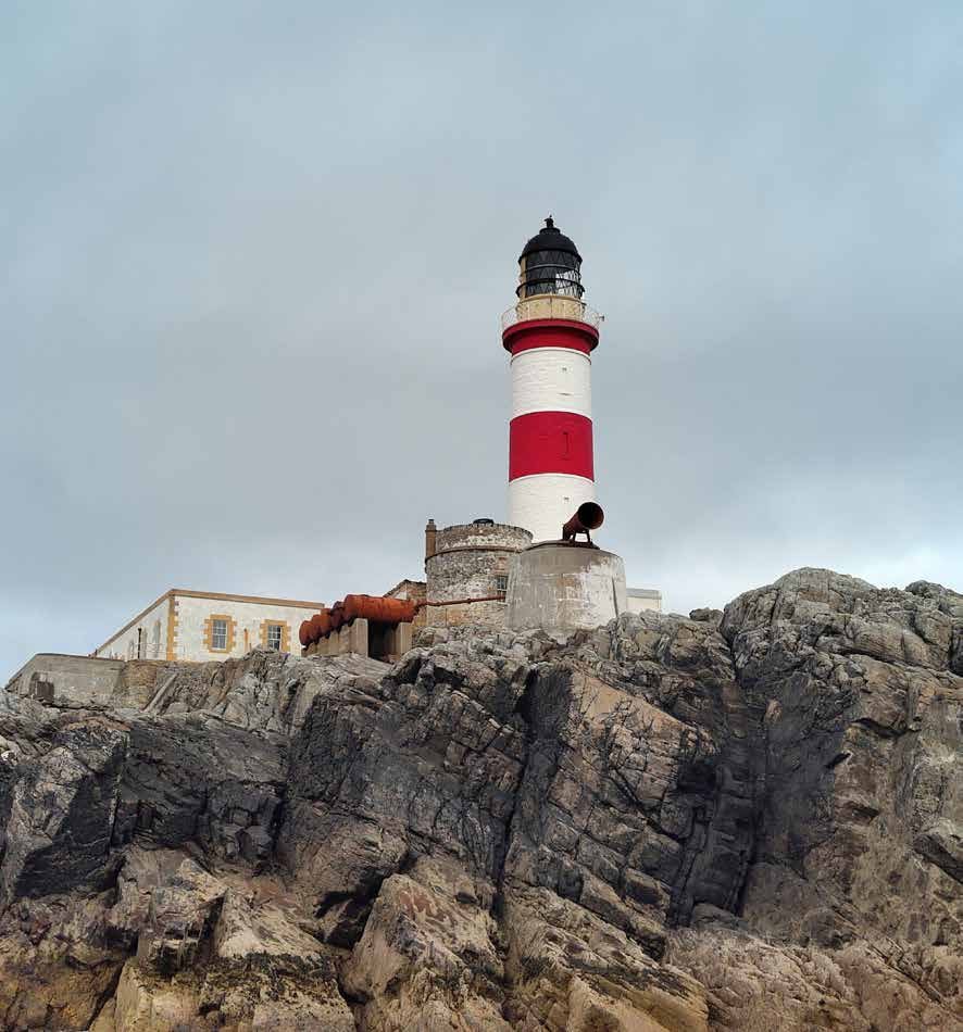Rot-weißer Leuchtturm auf einem Felsen vor der schottischen Westküste