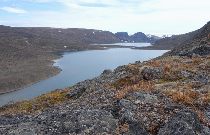Weites Tundratal mit See auf Nordaustlandet in Spitzbergen, im Hintergrund Berge