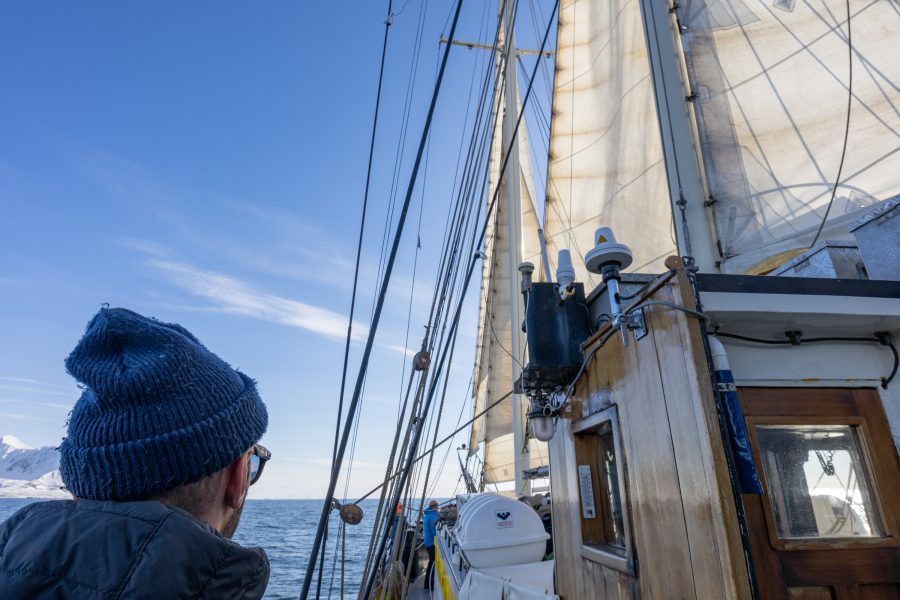 Blick vom Deck eines Segelschiffs unter gesetzten Segeln im Forlandsundet